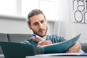 Canvas Print - Handsome young man working at home, closeup