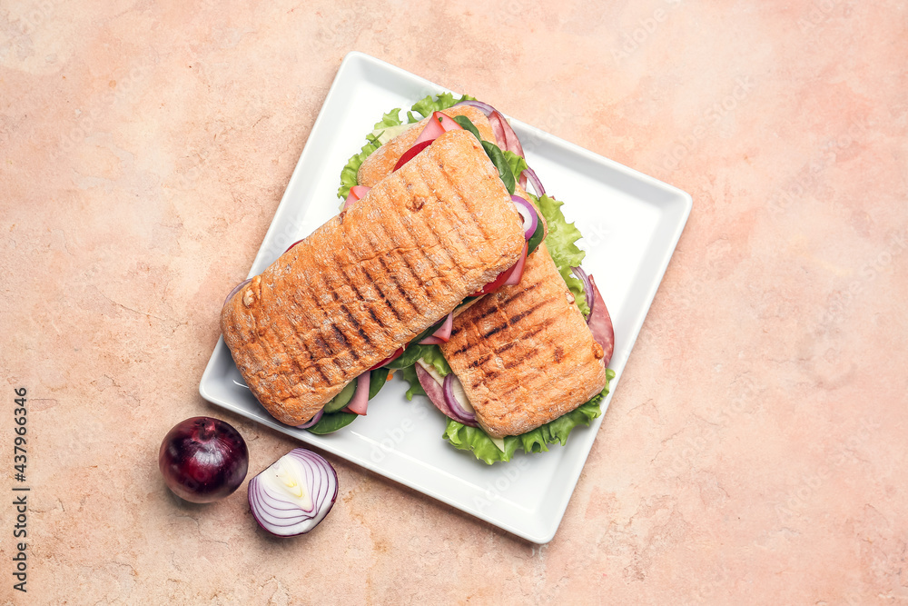 Plate with tasty ciabatta sandwiches on color background