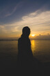 © Thien An Vu - Back view silhouette young girl asian with depressed pose on the beach at sunset. Beautiful blonde woman with long hair depressing at the ocean. Concept of depress, sad