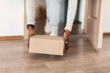 Unrecognizable Black Female Taking Delivered Parcel Box Entering Home