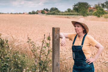 Wall Mural - Female farmer posing in ripe barley field just before the harvest