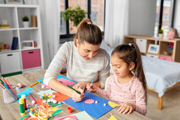 Wall Mural - family, art and craft concept - mother spending time with her little daughter making applique of color paper at home