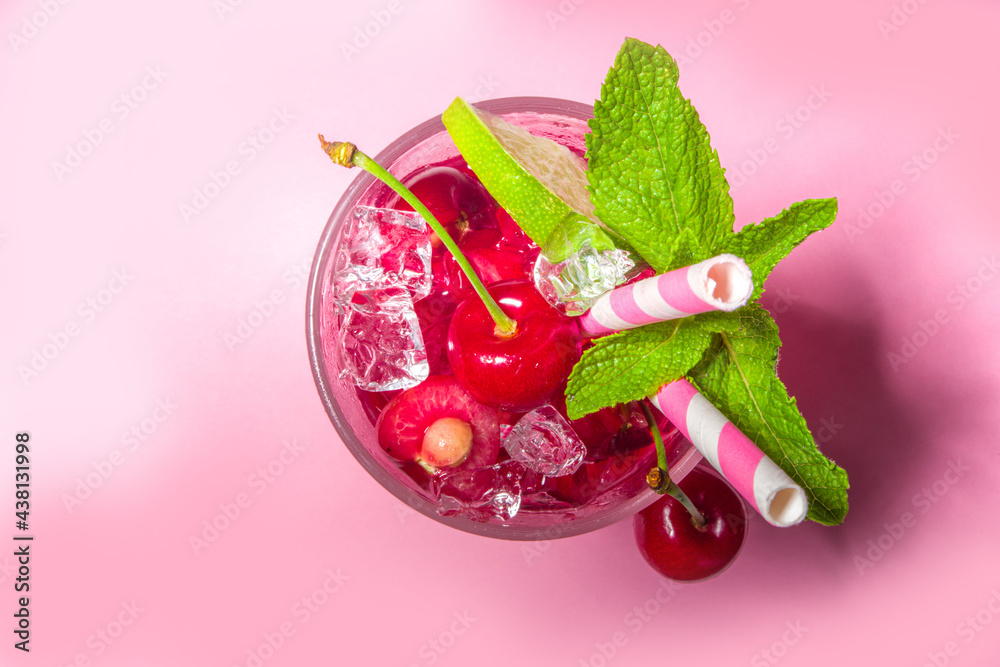 Cold and refreshing summer drink. Cherry cola, limeade, mojito lemonade cocktail with lime and cherries on colorful bright pink background - obrazy, fototapety, plakaty 