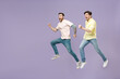 © ViDi Studio - Side view full length two young overjoyed smiling men friends together in casual t-shirt looking to each other hurrying up run jump high isolated on purple background studio People lifestyle concept