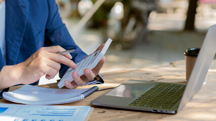 Young businessman working with laptop and graphing documents in company's multi-analysis and calculations.