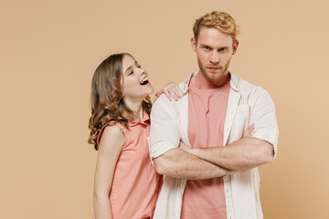 Wall Mural - Young caucasian offended frowning parent man with smiling child teen girl wearvcasual pastel clothes. Daddy little kid daughter hold hands crossed folded isolated on beige background studio portrait.