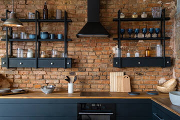 vew on open space industrial loft kitchen with vintage decor and black cabinets in daylight