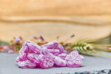Fototapeta Storczyk - Violet candies with natural wood background out of focus. Purple candies in the shape of a flower and sugar