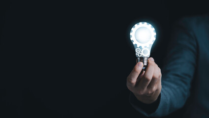 Poster - businessman holding blue mechanical gear with virtual light bulb for creative thinking idea and inno