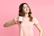 © GVS - Laughing beautiful woman with cup of coffee on pink background