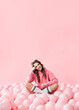 © GVS - Fashion portrait of young charming smiling woman posing with pink balloons on pink background