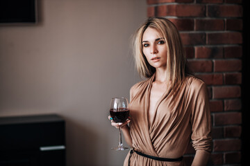 Wall Mural - A woman holds a glass of red wine in a restaurant.