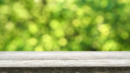 Wall Mural - Empty wooden table with fresh green bokeh background