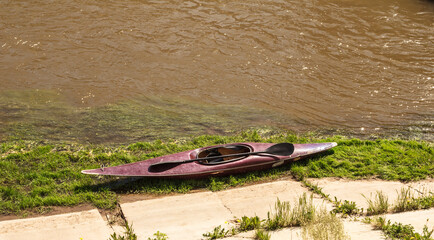 An old kayak on the river bank. Kayaking on the river. Water active sports