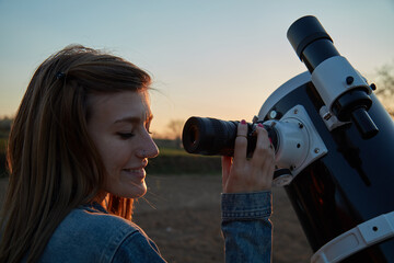 Wall Mural - woman looking at night sky with amateur astronomical telescope.