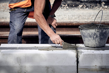 Wall Mural - Construction worker working on a public site reconstruction.