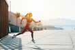 © zzzdim - Side view image of a brunette running on the pavement outdoors. Low angle