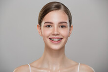 Portrait Of A Cute Smiling Girl In Braces. Gray Background.