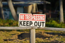 Old "No Trespassing. Keep Out" Sign On A Wooden Fence