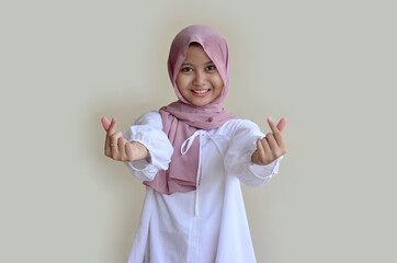 Indonesian Muslim teenage girl with smiling expression and hand sign of love