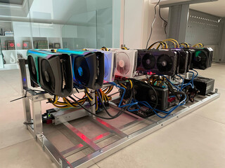 Fototapete - Row of bitcoin miners set up on the wired shelfs. Device for mining crypto currency. Mining cryptocurrency. Bitcoin farm. Machines for mining cryptocurrency bitcoin. Electronic device at day.