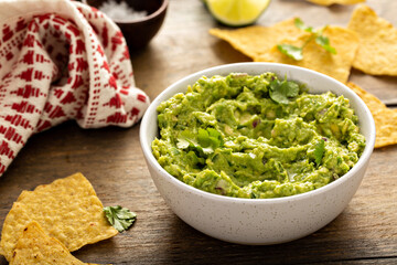 Wall Mural - Chunky homemade guacamole in a bowl with tortilla chips