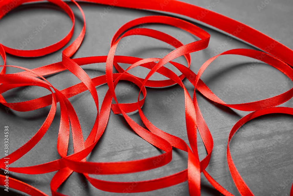 Red ribbons on dark background, closeup