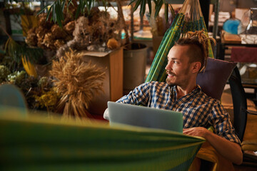 Wall Mural - Handsome young man using modern laptop at home