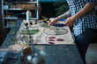 Male herbalist in plaid shirt making herbarium at home