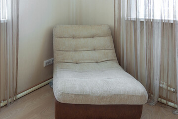 In the corner of the room there is a modern light chair comfortable and stylish