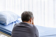 Relative of patient grieving on bed in the hospital ward.
