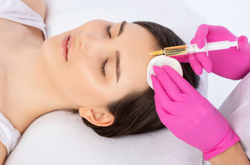 cosmetologist does prp therapy of a beautiful woman in a beauty salon. cosmetology concept.