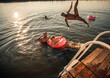 © Zoran Zeremski - Young friends having fun enjoying a summer day swimming and jumping at the lake.