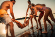 © Zoran Zeremski - Young friends having fun enjoying a summer day swimming and jumping at the lake.