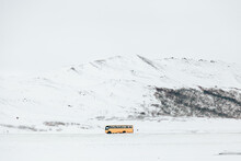 Yellow Bus On Snowy Mountains On Winter Day