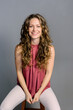 © ADDICTIVE STOCK - Attractive smiling woman sitting in a chair