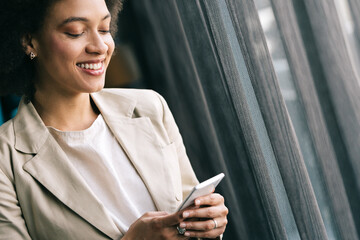 Sticker - Casual beautiful black businesswoman using phone in her office