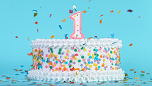 Colorful Tasty Birthday Cake With Candles Shaped Like The Number 1. Pastel Blue Background.