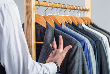 Male suits hanging in a row. Men clothing, boutiques. Man suit, tailor in his workshop. Fashion man in classical costume suit. Tailor, tailoring. Stylish men's suit