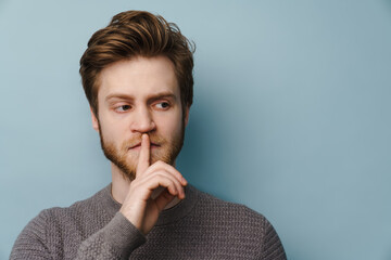 White ginger man with beard showing silence gesture at camera