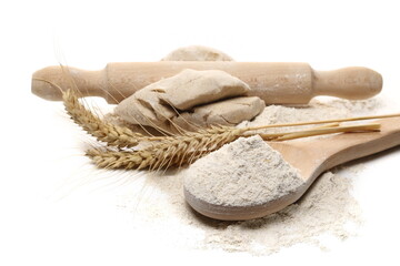 Dough and barley flour with wooden spoon and wheat ears isolated on white background