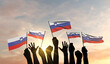 Silhouette of arms raised waving a Slovenia flag with pride. 3D Rendering