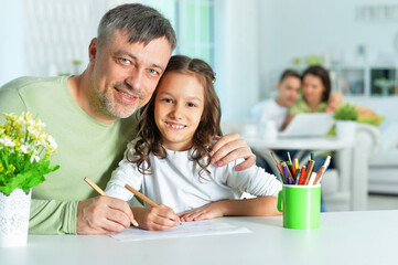 Wall Mural - Portrait of happy father and his cute daughter drawing