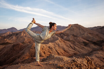 Canvas Print - Woman practicing yoga in the mountains in the desert