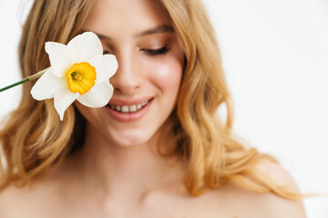 Canvas Print - Half-naked blonde woman smiling while posing with daffodil