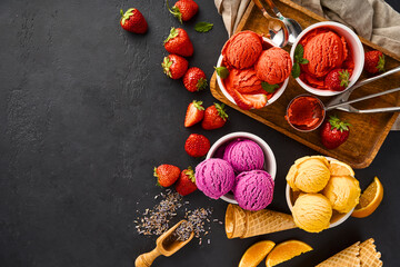 Aufkleber - Heap of strawberry and orange, dried lavender with cups of ice cream. Lavender, strawberry and orange sorbet on black background with copy space.