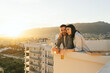 People enjoying cityscape and seaside view, drinking beer and eating pizza on the rooftop. Happy couple spend quarantine time, picnic leisure on the roof on the sunset.
