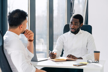 Business meeting in office. Employment interview. Two business partners are talking while sitting at the table.