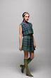 © LIGHTFIELD STUDIOS - full length of young woman in headband and retro checkered outfit posing on grey.