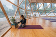 © ADDICTIVE STOCK - Relaxed woman sitting on yoga mat in hall by flower